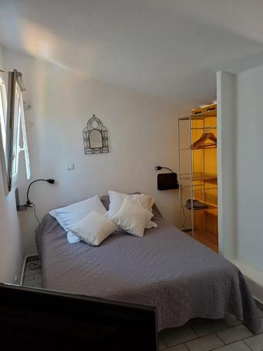 - une chambre avec un lit doté d'oreillers et une télévision dans l'établissement Mini villa résidence RIVIERA avec piscine proche Porto Vecchio, à Lecci