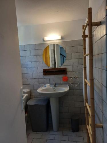 une salle de bain avec un lavabo et un miroir dans l'établissement Mini villa résidence RIVIERA avec piscine proche Porto Vecchio, à Lecci