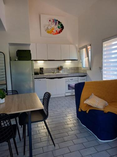 une cuisine avec une table et un canapé bleu dans l'établissement Mini villa résidence RIVIERA avec piscine proche Porto Vecchio, à Lecci