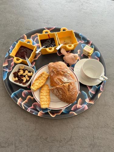 ein Teller mit Essen, auf dem Brot und andere Lebensmittel liegen in der Unterkunft Le repaire des trois singes in Brésilley