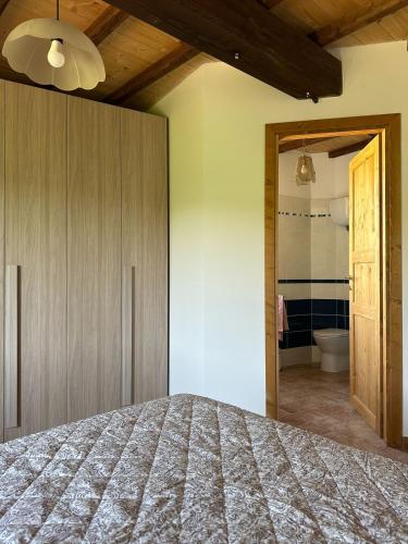 a bedroom with a bed and a bathroom at Agriturismo Le Rocchette in Rocchette