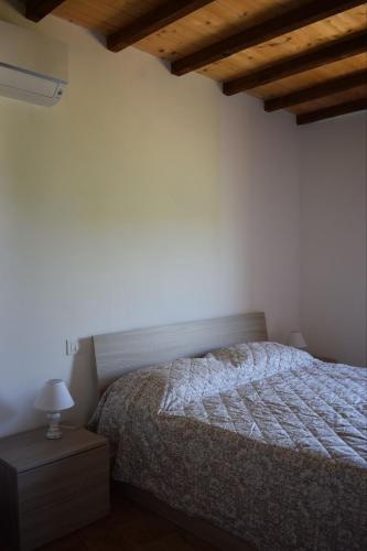 a bedroom with a bed and a lamp on a night stand at Agriturismo Le Rocchette in Rocchette
