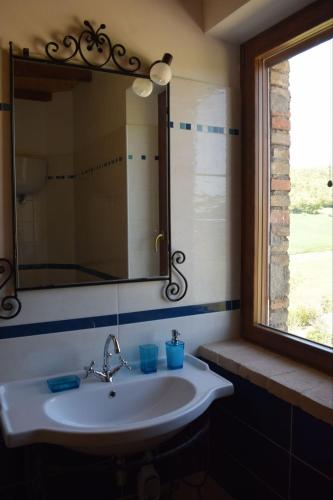 a bathroom with a sink and a mirror and a window at Agriturismo Le Rocchette in Rocchette