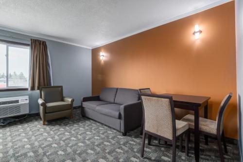 a living room with a couch and a table at Airport Traveller's Inn in Calgary