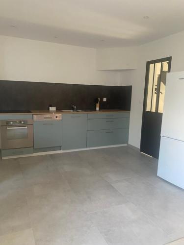 una cucina con mobili grigi e una parete nera di La maison de Julien a Bourbourg