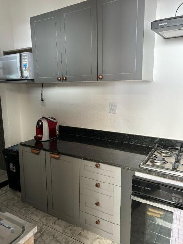 a kitchen with white cabinets and a counter top at confortavel como sua propria casa in Uberlândia