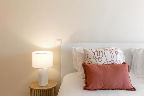 a bed with a lamp and a pillow on it at Sunset Retreat in Nazaré