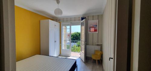 - une chambre avec un lit et un mur jaune dans l'établissement NATURE by Reine du Sud, proche des Grands Buffets, à Narbonne