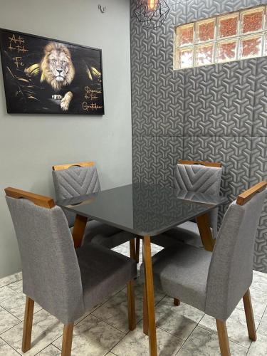 a dining room table with chairs and a picture of a lion at confortavel como sua propria casa in Uberlândia