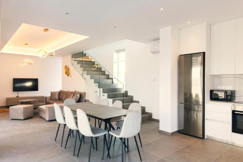 a kitchen and dining room with a table and chairs at Nissinest Luxury Villas in Ayia Napa