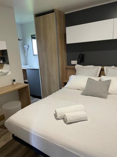 una camera da letto con un grande letto bianco con due asciugamani sopra di Camp'hôtel Domaine du perche Bellêmois a Bellême