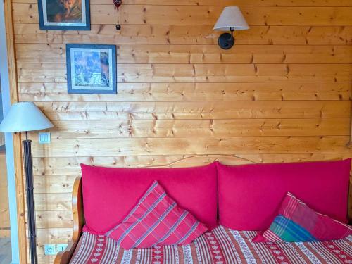 圣母贝莱克Appartement cosy à Notre-Dame-de-Bellecombe, superbe vue - FR-1-807-69的一间卧室配有一张粉红色的床和木墙