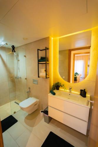 Un baño con lavabo, inodoro y espejo. en Amberdi Noria Apartment Marrakech, en Marrakech