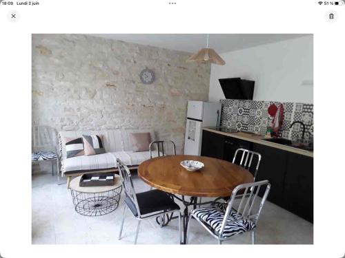 un soggiorno con tavolo, sedie e divano di Gîte La Maison d Hélène a Millac