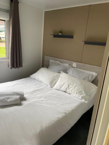 a large white bed with white sheets and pillows at Camp'hôtel Domaine du perche Bellêmois in Bellême