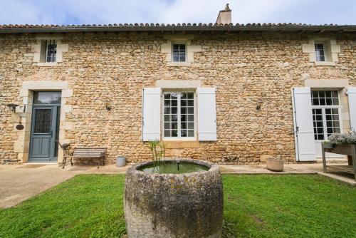 a stone building with a bench in front of it at La Bégasserie Ancienne maison de maître de 1700 in Château-Larcher