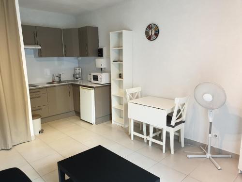 Elle comprend une petite cuisine avec une table et un bureau. dans l'établissement Studio avec jardin proche de la Mer, au Pradet