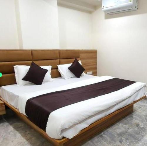 a bedroom with a large bed with white and black pillows at The Gravity Hotel in Ahmedabad