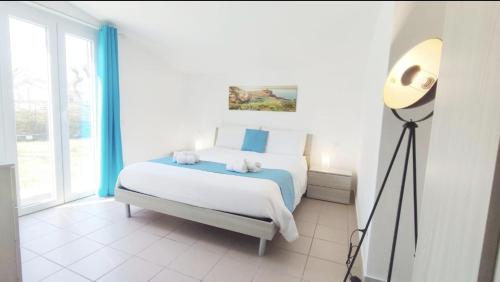 a bedroom with a bed and a floor lamp at Voglio Vivere Così in Santo Stefano di Magra