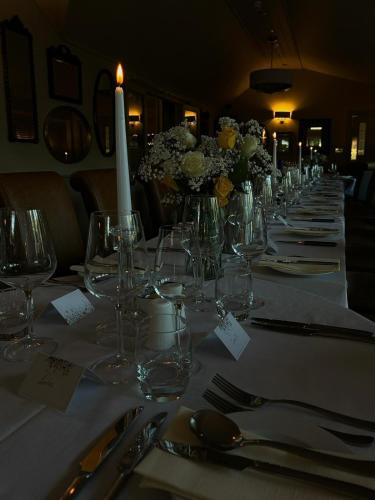 a long table with wine glasses and flowers on it at The Angel Inn in Thirsk