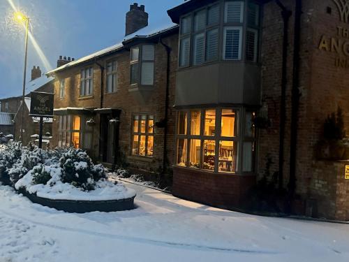 a snow covered street in front of a building at The Angel Inn in Thirsk