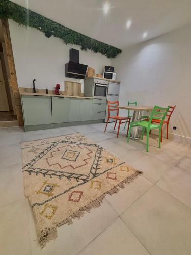 une cuisine avec des chaises vertes et une table avec un tapis dans l'établissement Au cœur du Beausset, au Beausset