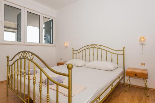 a bedroom with a bed and a window at Andrijas Apartments in Tribunj