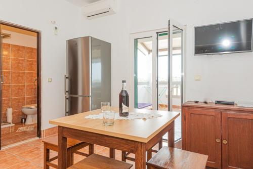 a room with a table with a bottle of wine on it at Andrijas Apartments in Tribunj