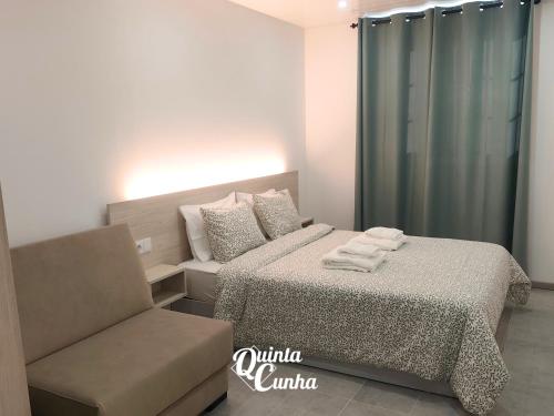 a bedroom with a bed and a couch and a chair at Quinta Cunha in São Pedro do Sul