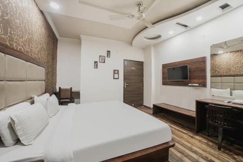 a bedroom with a bed and a desk and a television at Townhouse Hollywood Heights in Amritsar