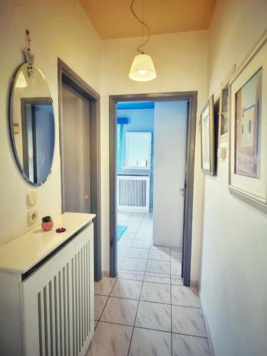 a bathroom with a sink and a mirror and a hallway at Elia Apartment in Paralion astros