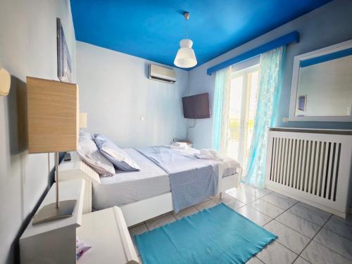 a bedroom with a bed and a blue ceiling at Elia Apartment in Paralion astros