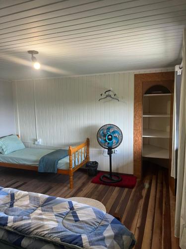 a bedroom with a bed and a desk and a fan at Espia Mata - Pousada Hostel in Ponta Grossa