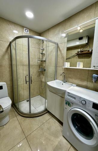 a bathroom with a shower and a washing machine at Gonio Horizon Apartment in Gonio