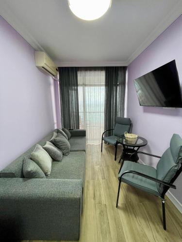 a living room with a couch and a tv and chairs at Gonio Horizon Apartment in Gonio
