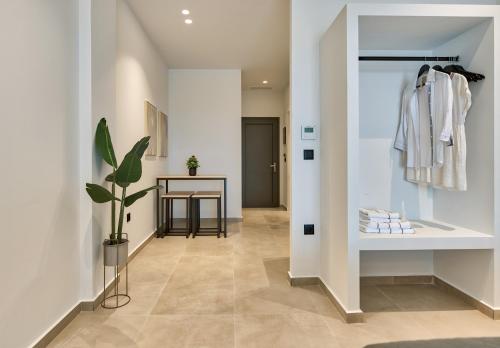 a hallway with a closet with a table and a coat rack at Marea Luxury Suites in Koríthion