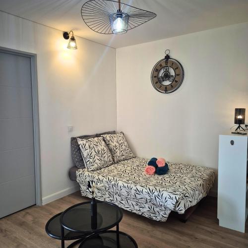 un salon avec un canapé et une horloge au mur dans l'établissement Appartement lumineux avec vue sur le port, plage à 10 min à pied - Proche tout commerces, à Mauguio