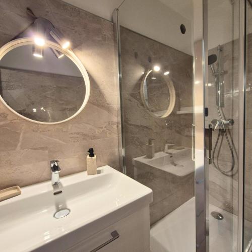 une salle de bain avec un lavabo, un miroir et une douche dans l'établissement Appartement lumineux avec vue sur le port, plage à 10 min à pied - Proche tout commerces, à Mauguio