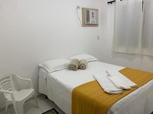 a bedroom with a bed with towels and a chair at Apartamento Morada do Vale 1 andar - Área de Lazer - Estacionamento - Internet e Netflix GRATUITO in Garanhuns