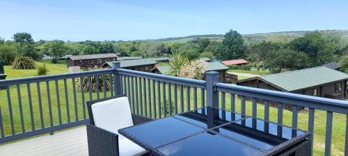 a balcony with a white chair and a fence at Lake view in Newquay