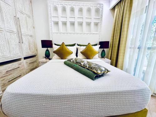 a bedroom with a large white bed with yellow pillows at Cosy One Bedroom Apartment-Diani in Diani Beach