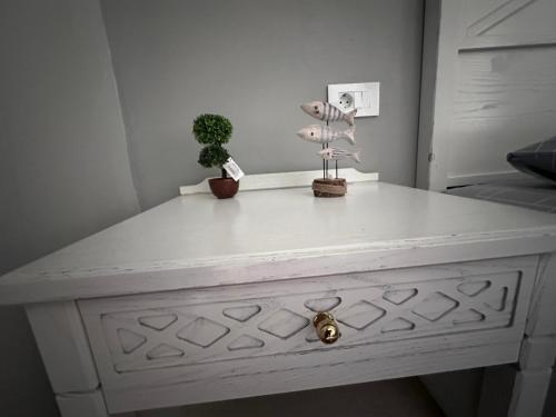 a white dresser with a plant on top of it at Dionysia Studios in Kefalos