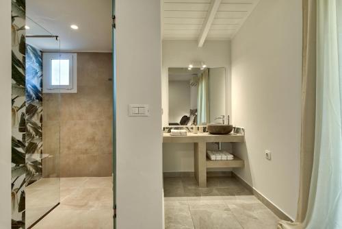 a bathroom with a sink and a mirror at Marea Luxury Suites in Koríthion