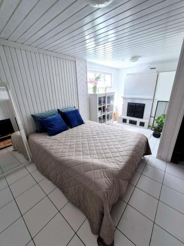 a bedroom with a large bed with blue pillows at Villa Mosahiisi Charming Poolside Getaway in Helsinki