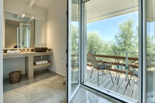 a bathroom with a glass door leading to a balcony at Marea Luxury Suites in Koríthion