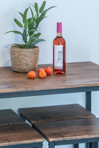 a bottle of wine sitting on a table with oranges at Marea Luxury Suites in Koríthion