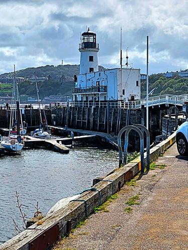 a lighthouse in a marina with boats in the water at 5 Prospect Place - 2nd floor Dream View in Scarborough