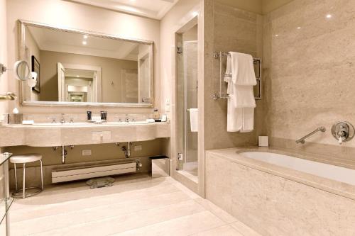 a bathroom with a tub and a sink and a mirror at San Clemente Palace Venice in Venice