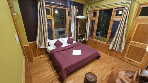 a bedroom with a bed with a purple comforter at Kintsugi by Oztel in Kasol