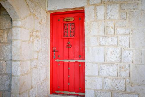a red door in the corner of a stone wall at Chateau Du Comte 